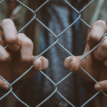 Man standing behind a bunch of barriers to self-care